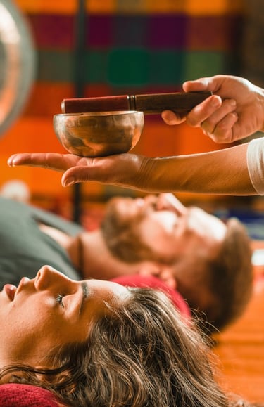 Un homme et une femme sont en train de participer à une séances de massage sonore collectif.
