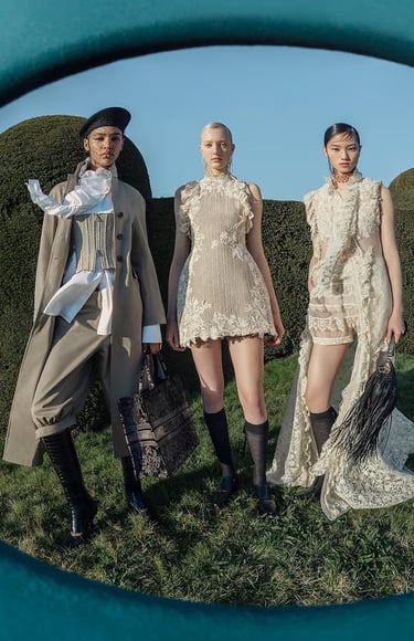Three models in Dior couture posing outdoors in structured and lace ensembles.