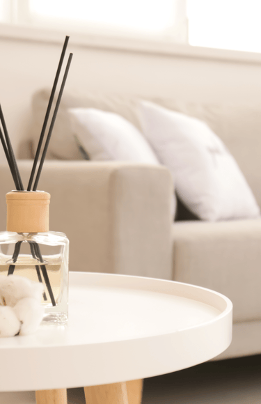 a table with a glass vase and a candle on it