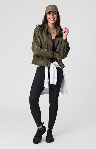 Fashion e-commerce photography - a woman in a green jacket and black leggings