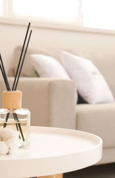 a table with a glass vase and a candle on it