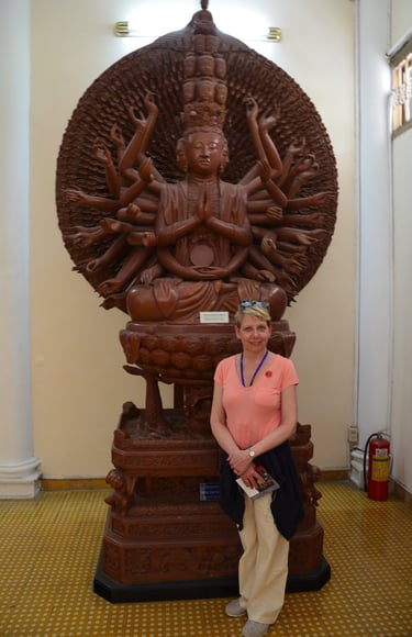 Lady Michelle poses in front of a wooden sculpture at the history museum, Ho Chi Minh City, Vietnam