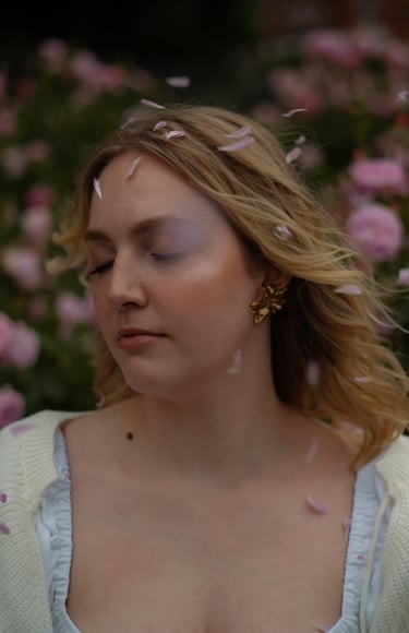 woman with closed eyes and rose petals around her