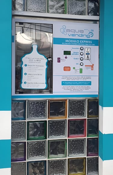 Aqua Vending water refill station machine built into a wall of decorative glass blocks.