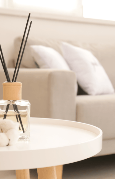 a table with a glass vase and a candle on it