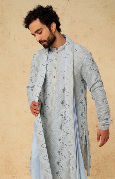a man in a blue and white indian wedding suit