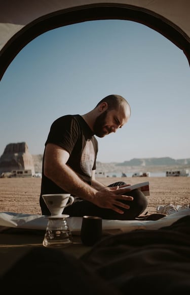 a man sitting in a tent with a laptop