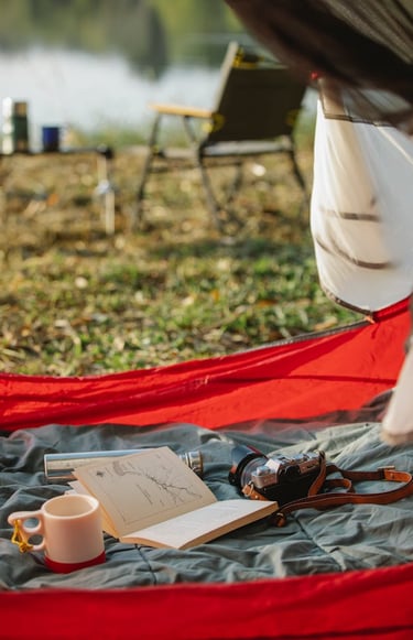 a person sitting in a hammock with a cup of coffee