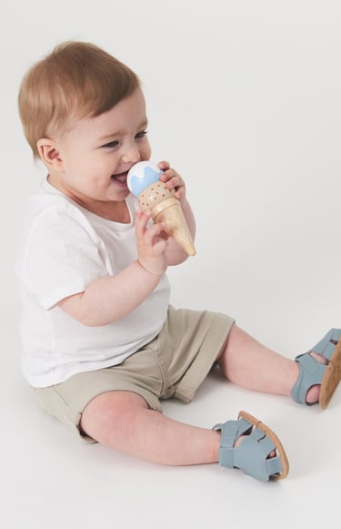 Fashion campaign photography - a baby boy sitting on the floor with a ice cream