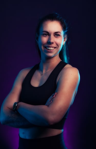 portrait photo of a woman in a black top and a purple background