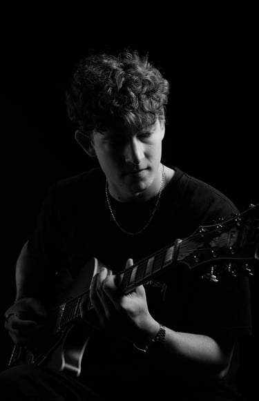 portrait of a man playing a guitar in a black and white photo
