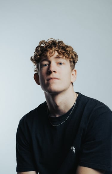 portrait of a man with curly hair and a black shirt