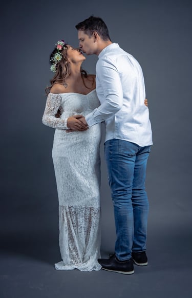 a pregnant woman in a white dress and a man in jeans and jeans