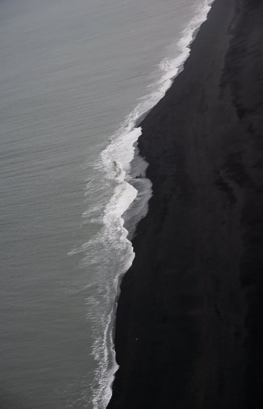 a person walking along a beach with a surfboard