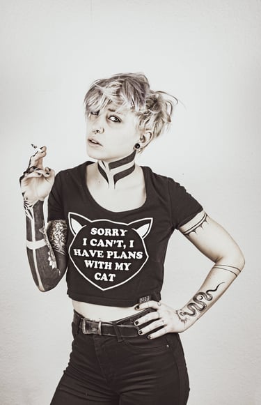a woman with tattoos on her arm and throat posing for a photo