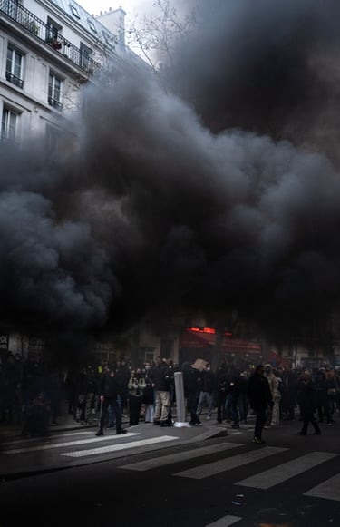 Manifestatioin contre la réforme des retraites. Une épaisee fumée survole les manifestants. 