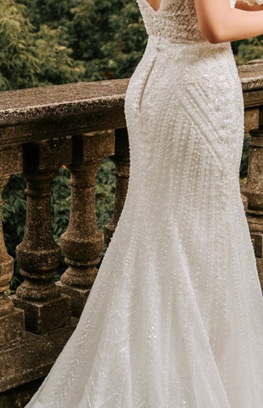 Bride holding a bouquet with her dress elegantly spread on the floor, wedding photography