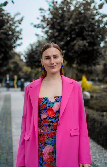 Bryllupsgæst i blomster skrædder kjole og pink blazer 