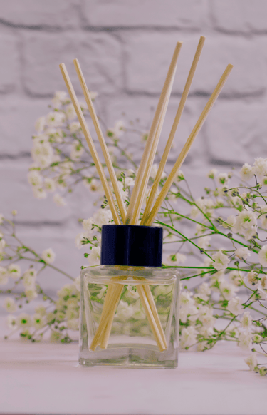 a glass bottle of perfume with a bunch of flowers