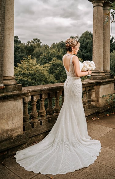 Bride holding a bouquet with her dress elegantly spread on the floor, wedding photography