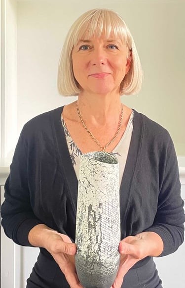 Rebecca Thomas holding a black and white ceramic vase