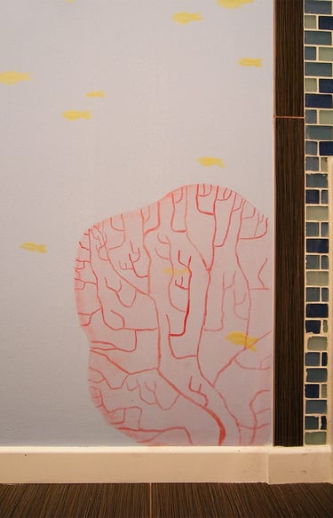 Hand-painted red coral and yellow fish painted in a contemporary style in a kid's bathroom.