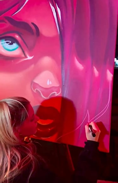 Ona Salvador realizando un live painting en un evento cultural.
