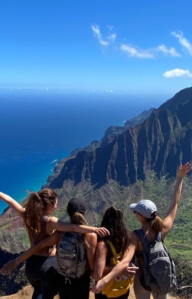 a group of fitness retreat guests posing at the top of a mountain