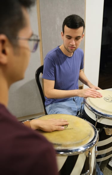Joven estudiante aprendiendo percusión y congas en monochrome records