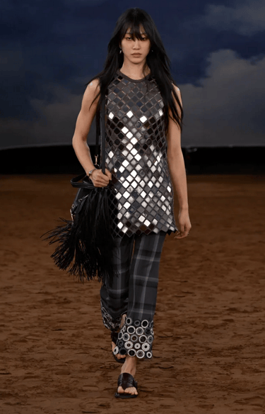 Burberry model in mirrored metallic top with checked trousers at London Fashion Week 2026.