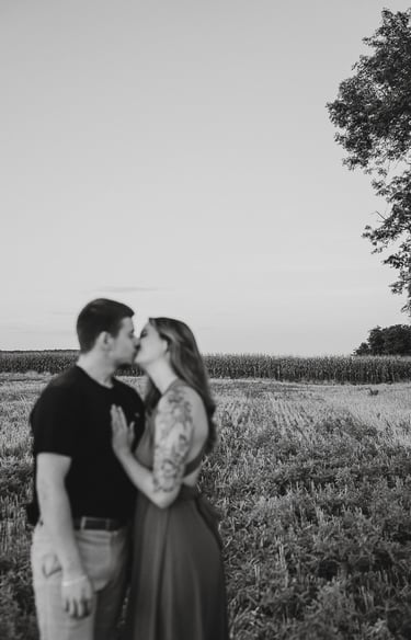 plan large d'une couple en noir et blanc qui s'embrasse premier plan flou paysage net