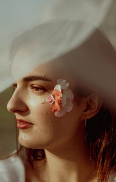 portrait rapproché d'un visage féminin de profil maquillé recouvert d'un voile en tulle transparent