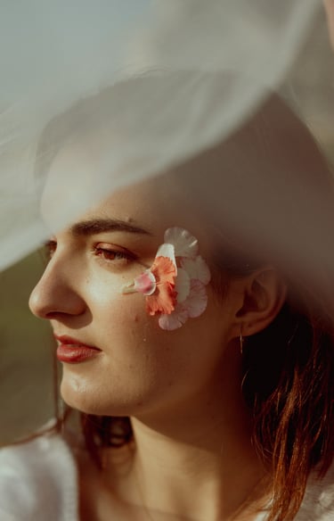 portrait rapproché d'un visage féminin de profil maquillé recouvert d'un voile en tulle transparent