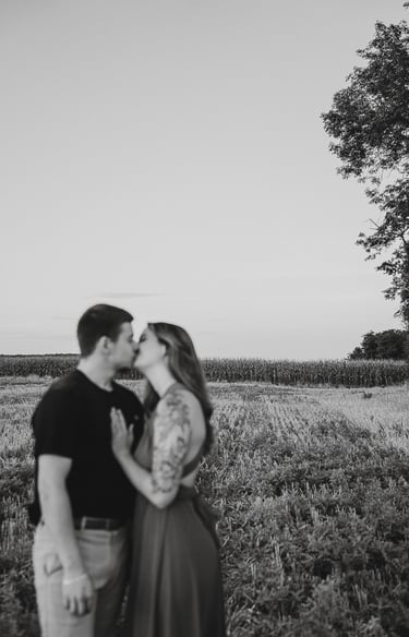 plan large d'une couple en noir et blanc qui s'embrasse premier plan flou paysage net