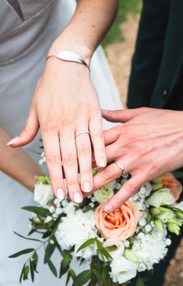 photo de couple lumineuse, les alliances des mariés, avec bouquet de fleurs