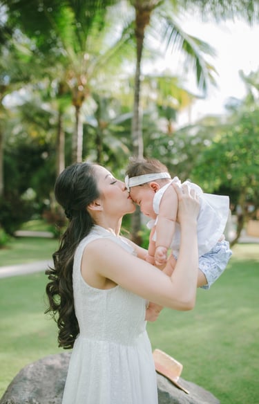 Mother lifting baby in garden during Sofitel Nusa Dua Bali family photography session