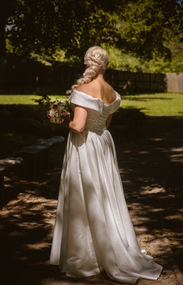 a woman in a white dress standing in a park