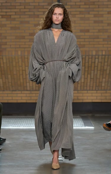 Calvin Klein Spring Summer 2026 runway look with flowing grey maxi dress and scarf detail.