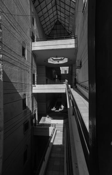 Black and white architectural photography of building interior with harsh shadows. Unseen Spaces