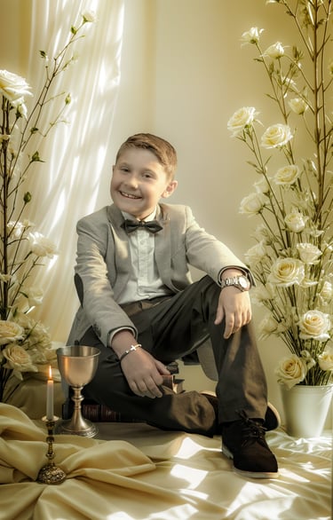 a boy in a suit and bow tie sitting on a bed