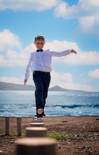 a young boy is walking on a wooden platform