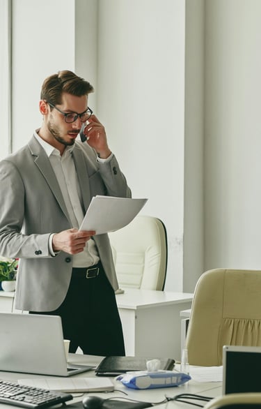 Young businessman talking consulting with a client on the phone and looking at documents.and