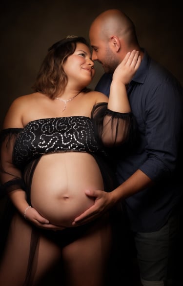 a pregnant woman in a black dress and a man in a black shirt