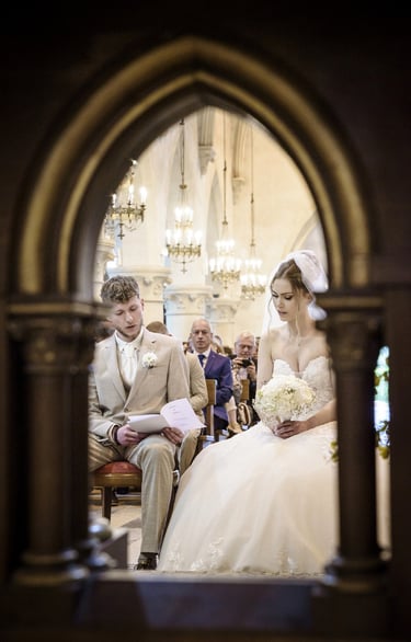 a bride and groom are sitting in a church
