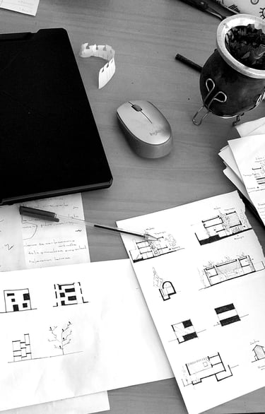 Foto de escritorio con dibujos y notebook. Arquitecto Pablo Suarez