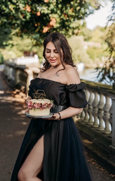 Outdoor portrait of woman in black dress holding cake – Fred Art Studio London
