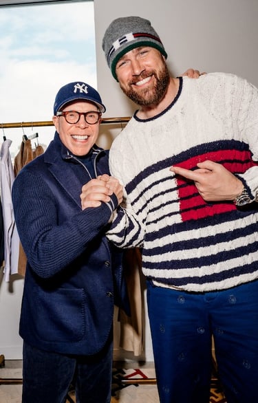 Tommy Hilfiger and Travis Kelce posing together at a fashion event wearing Tommy Hilfiger clothing.