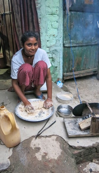 Woman cooking outside Delhi slum home