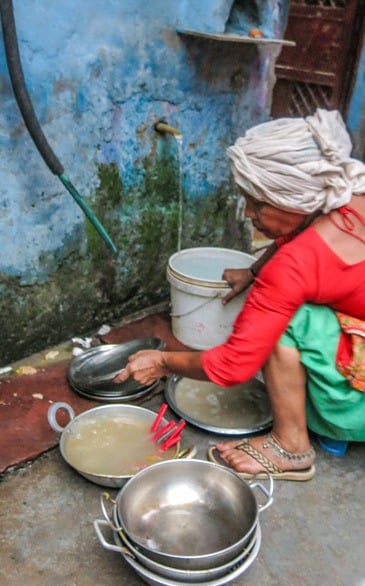 Woman cooking outside Delhi slum home