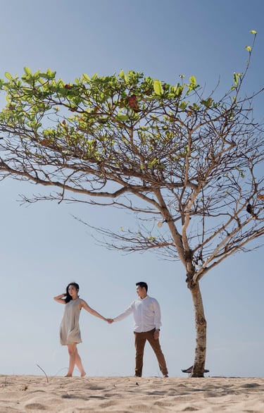 Intimate proposal couple under a lone tree at Sofitel Nusa Dua beach Bali